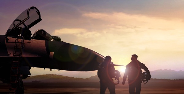 Two fighter pilots walk toward a jet
