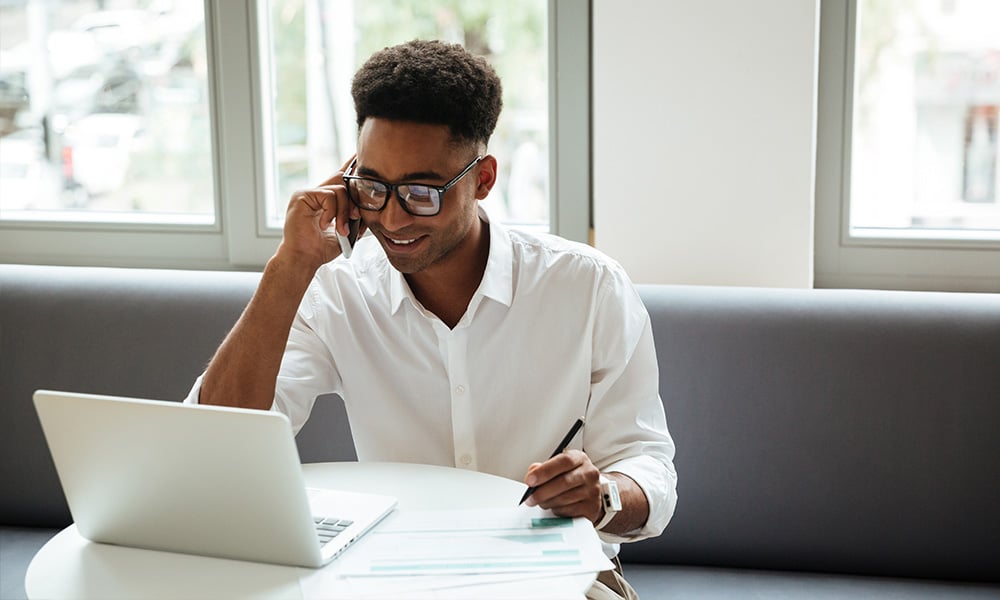 A broker talks on the phone with a client. 