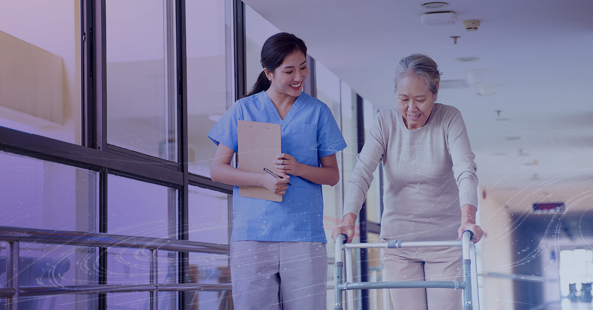 Physical Therapist walks with a patient down the hall. 