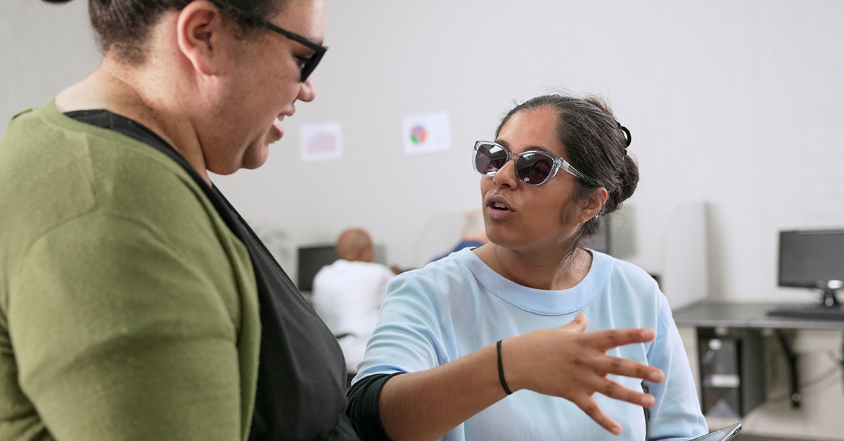 two women with low vision work together in an office