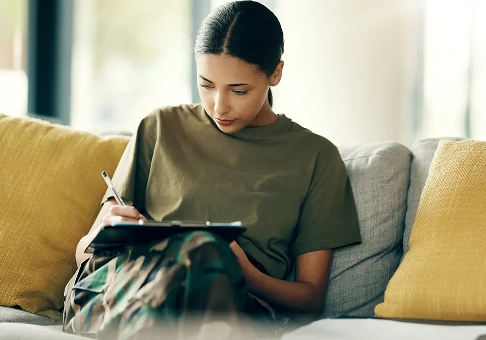 A veteran in fatigues fills out a medical intake form. 
