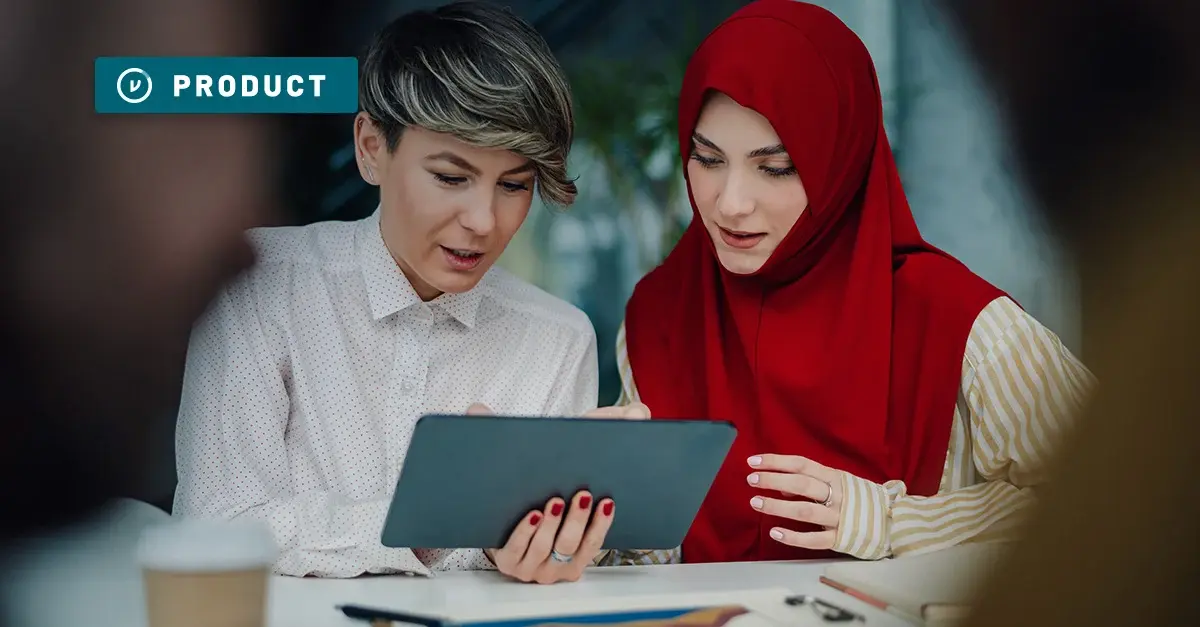 two women work together on a tablet in the office