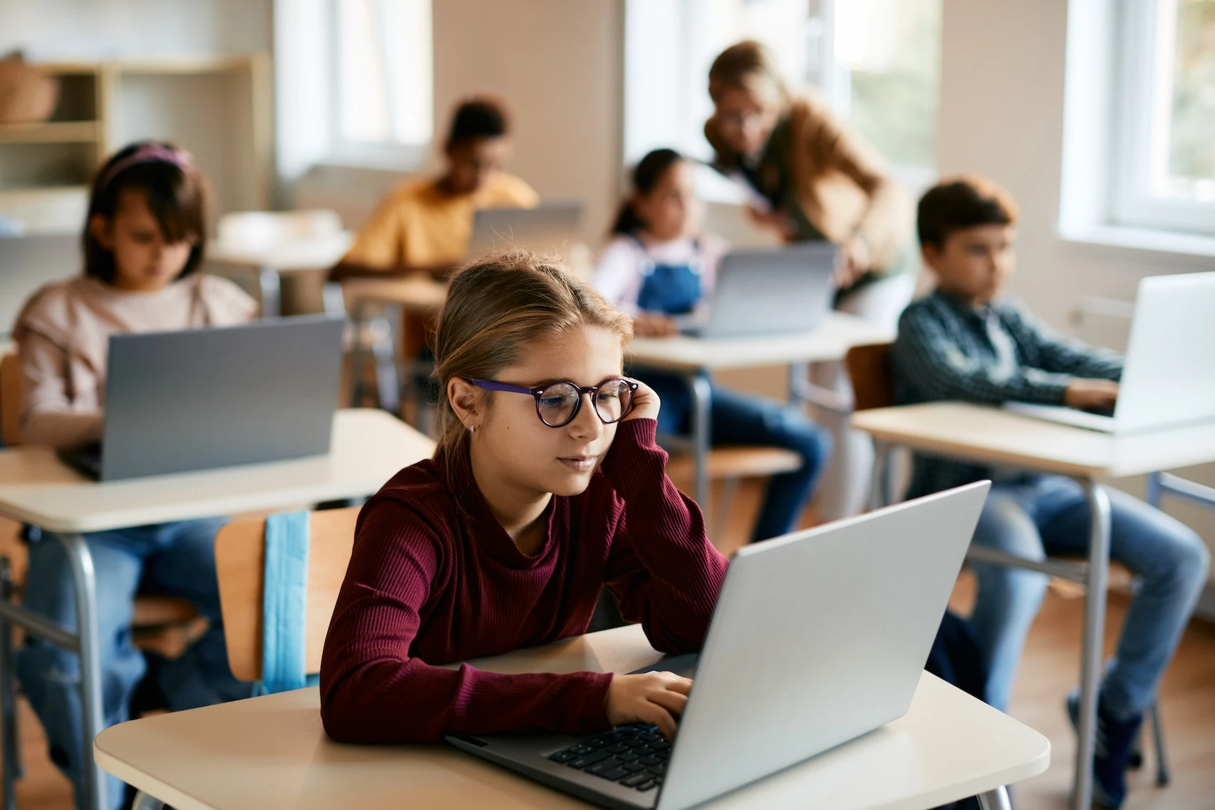 A classroom with children on laptops at their desks.