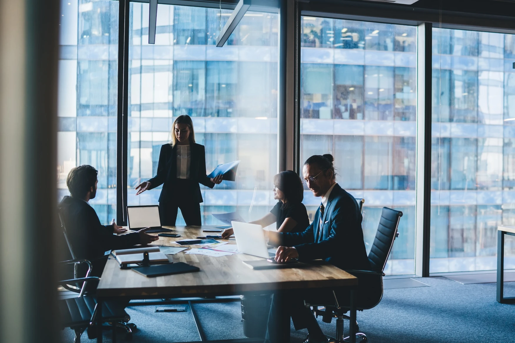 A woman addresses a meeting room of business people. 