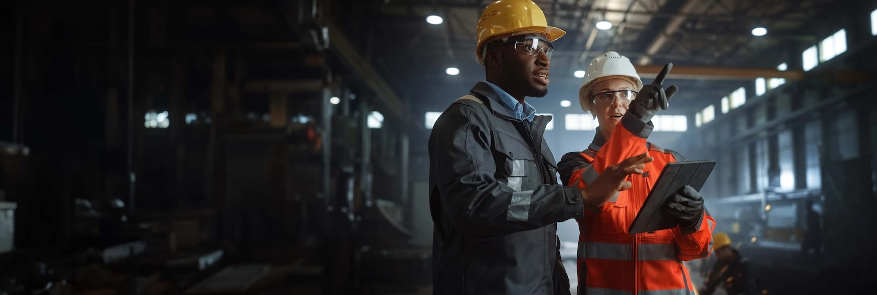 Manufacturing professionals looking at specs on a tablet