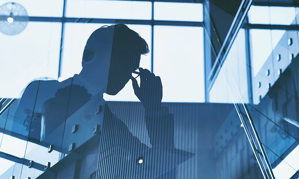 Reflection of a business man on a glass wall.