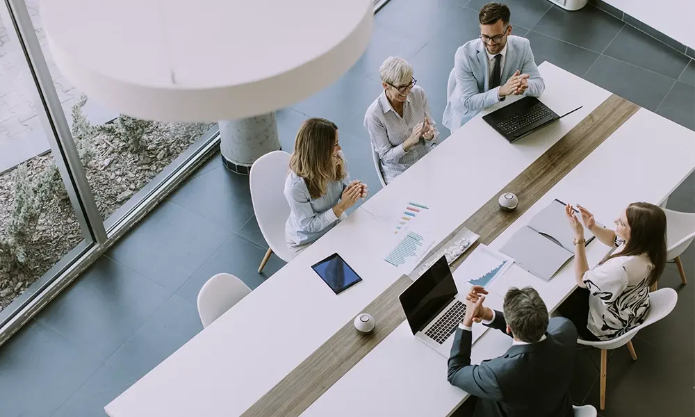 A team collaborates together at a long table.