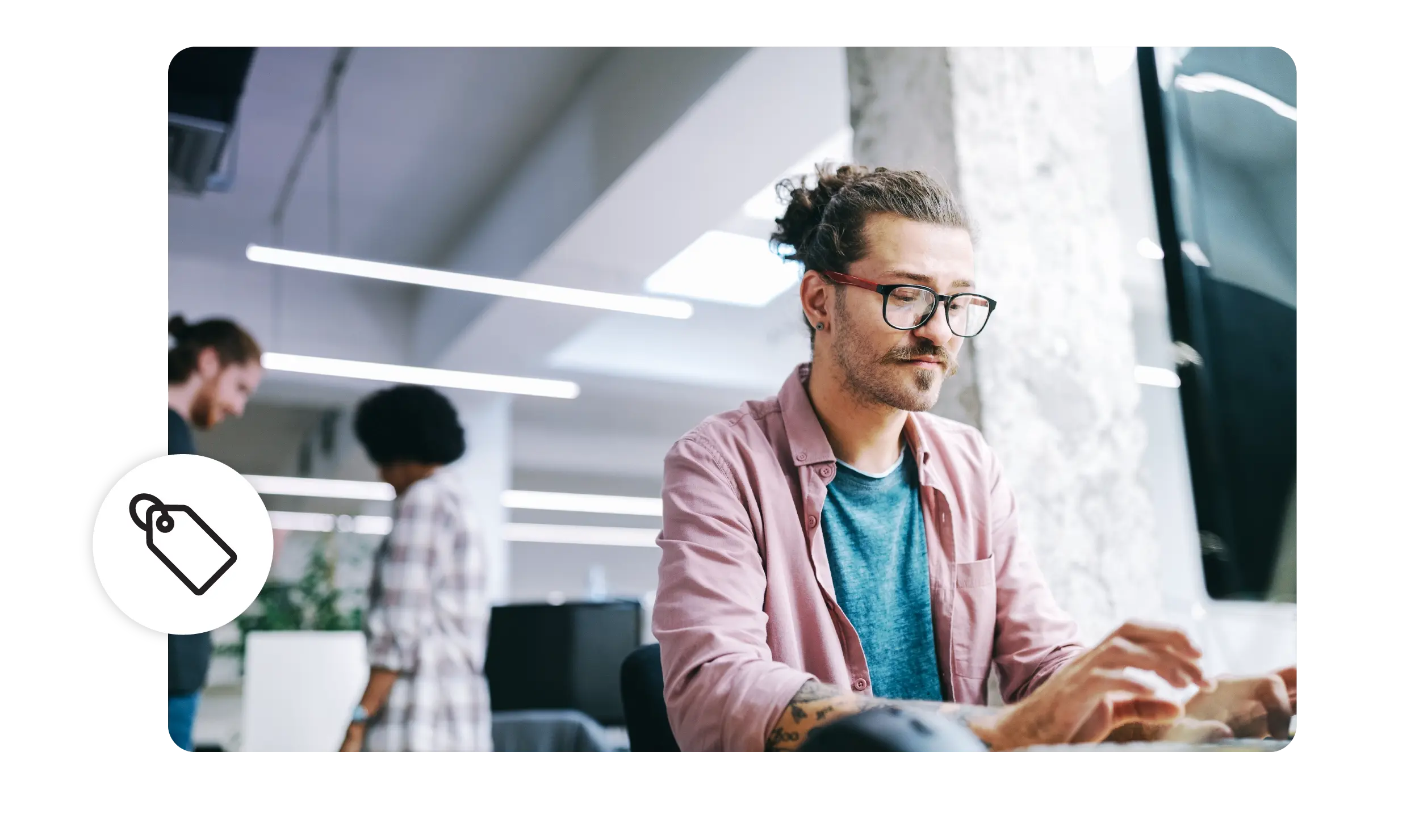 A man works in an office, typing on his computer. 