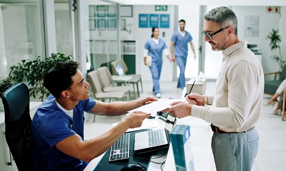 A nurse processes payment for a patient