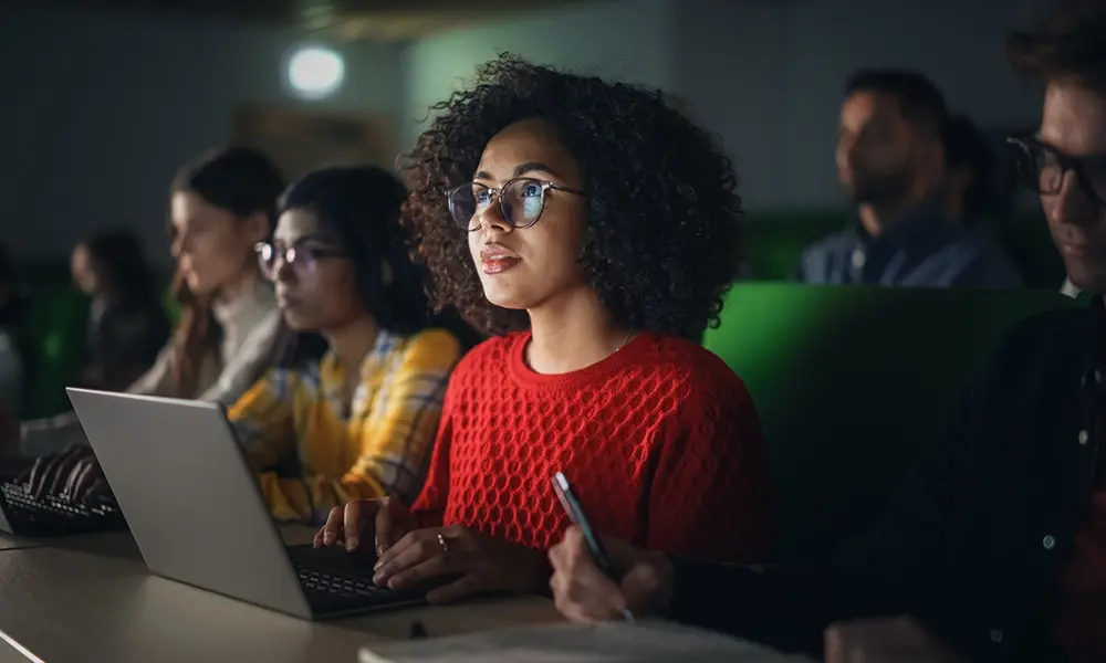 woman sits at her laptop in a lecture