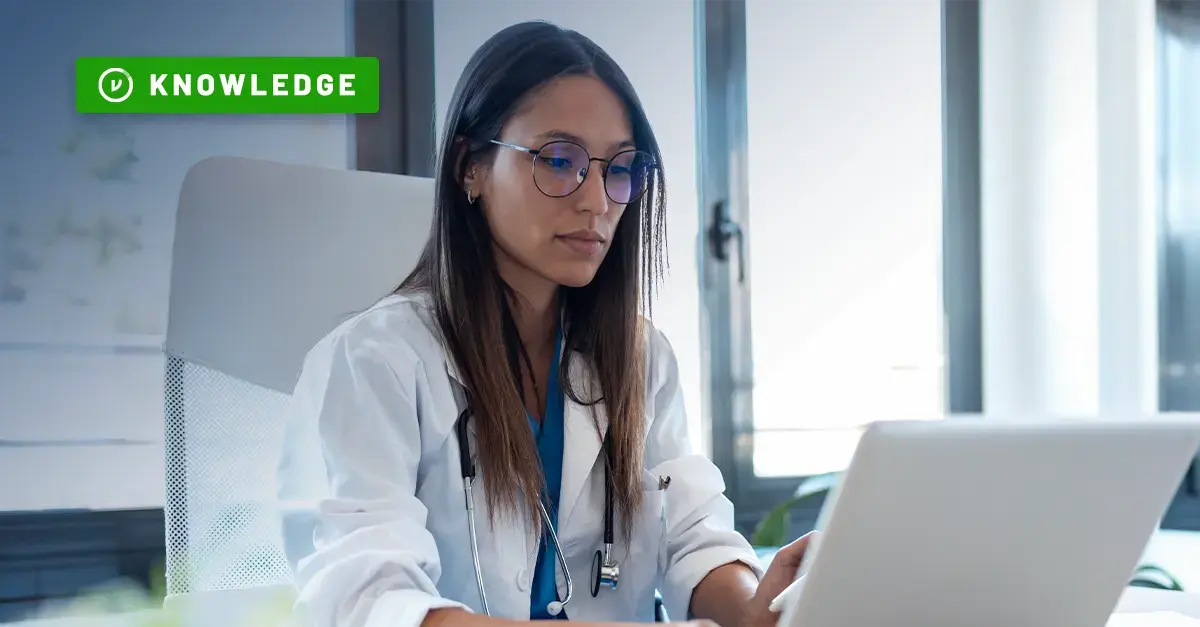 Doctor types on a laptop in medical facility