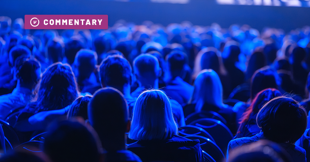 Crowd of seated conference goers sit in dark as they watch presentation at Black Hat 2026