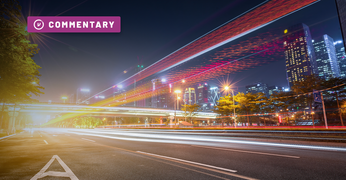 Lights stretch across a busy city street in long exposure at night