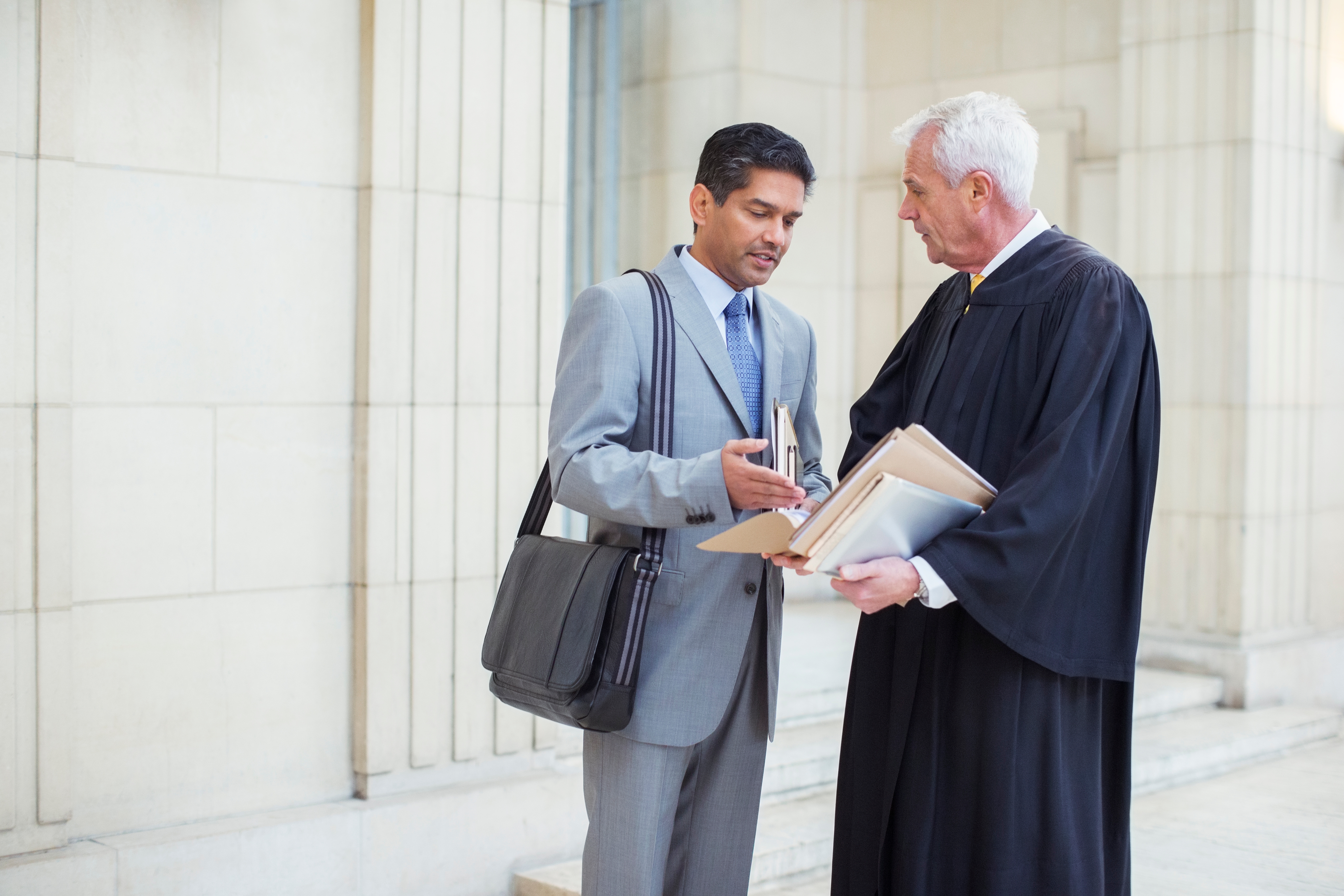 A judge and lawyer discuss a case outside of the courthouse