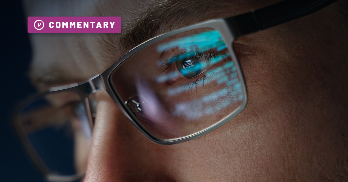 close up of eyes blocked by reading glasses, glowing from computer screen